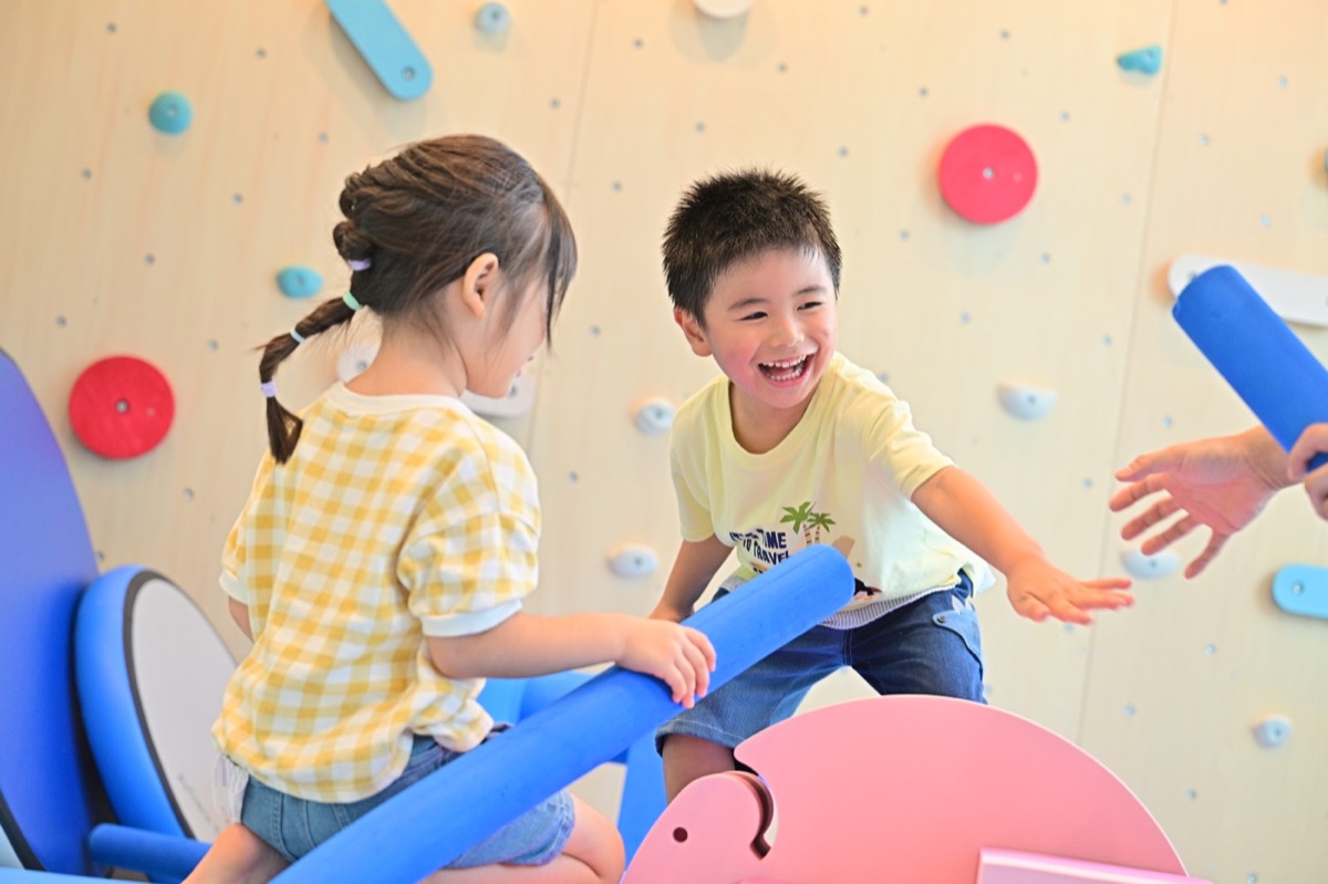 遊具を使って友だちと遊ぶ子どもたち